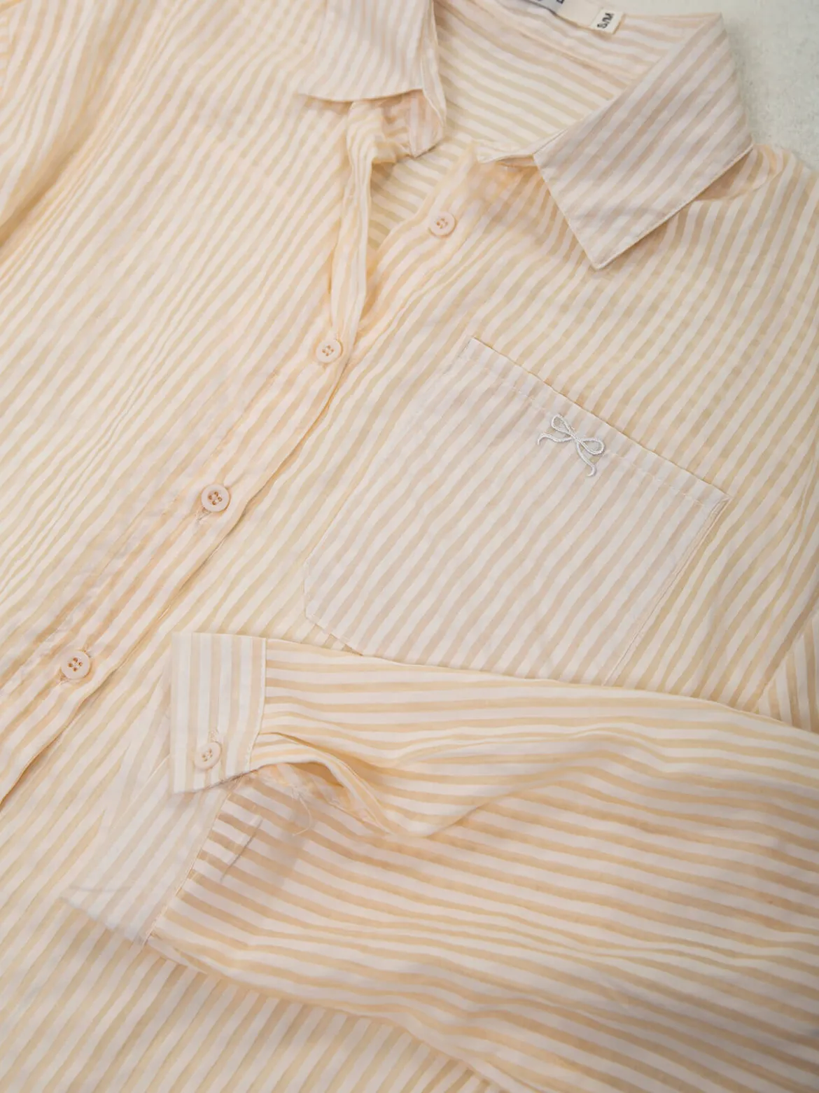 Camisa bege semitransparente às riscas